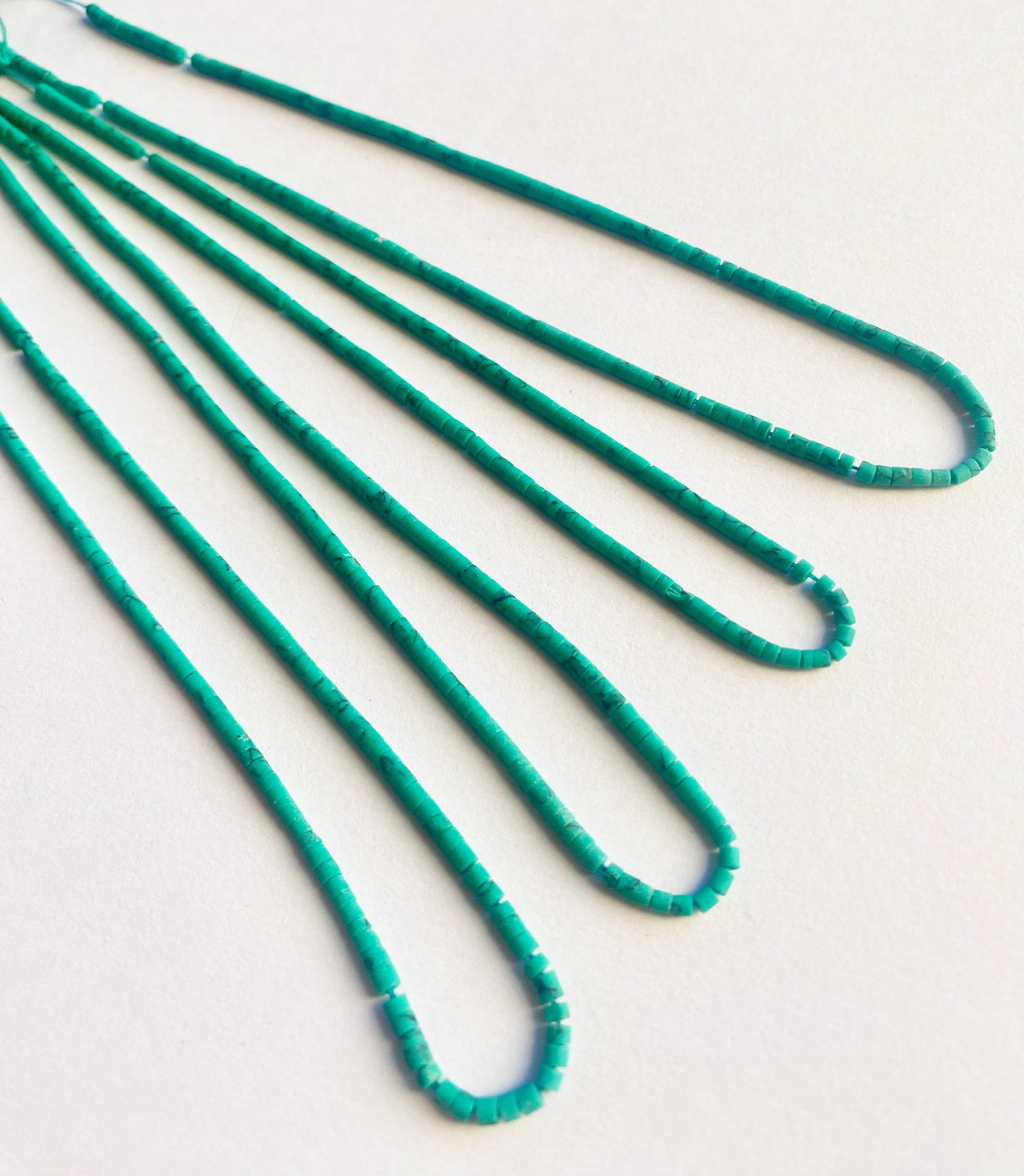 Tube-shaped Afghan Heishi beads in 2mm size arranged neatly on a 32cm strand with natural matte finish.