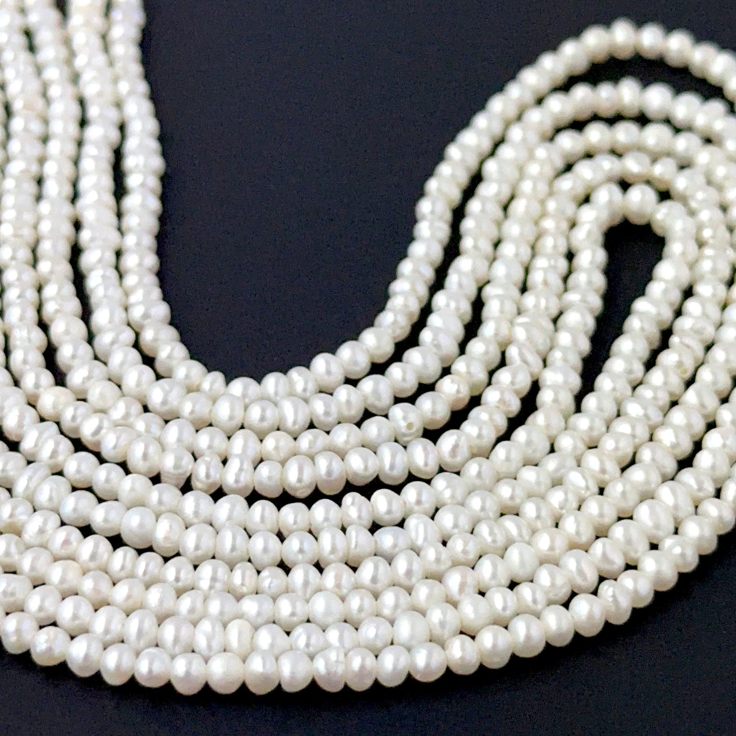 Freshwater pearl rondelles showing soft lustre and smooth handmade jewellery component quality.