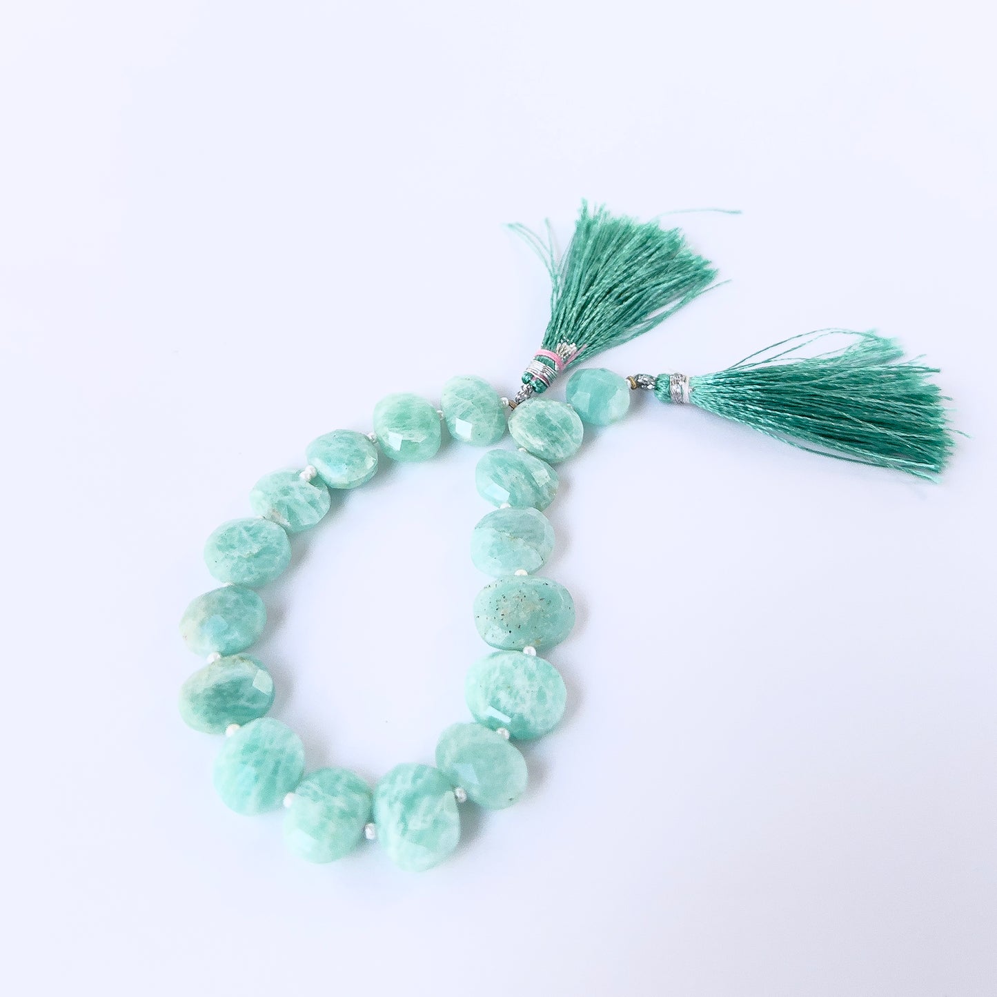 Close‑up of faceted Amazonite briolettes with polished shine, perfect for authentic gemstone bead jewellery.