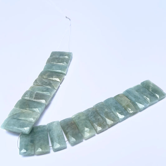 Amazonite faceted rectangle gemstone beads arranged in a V-shape with soft blue-green tones.