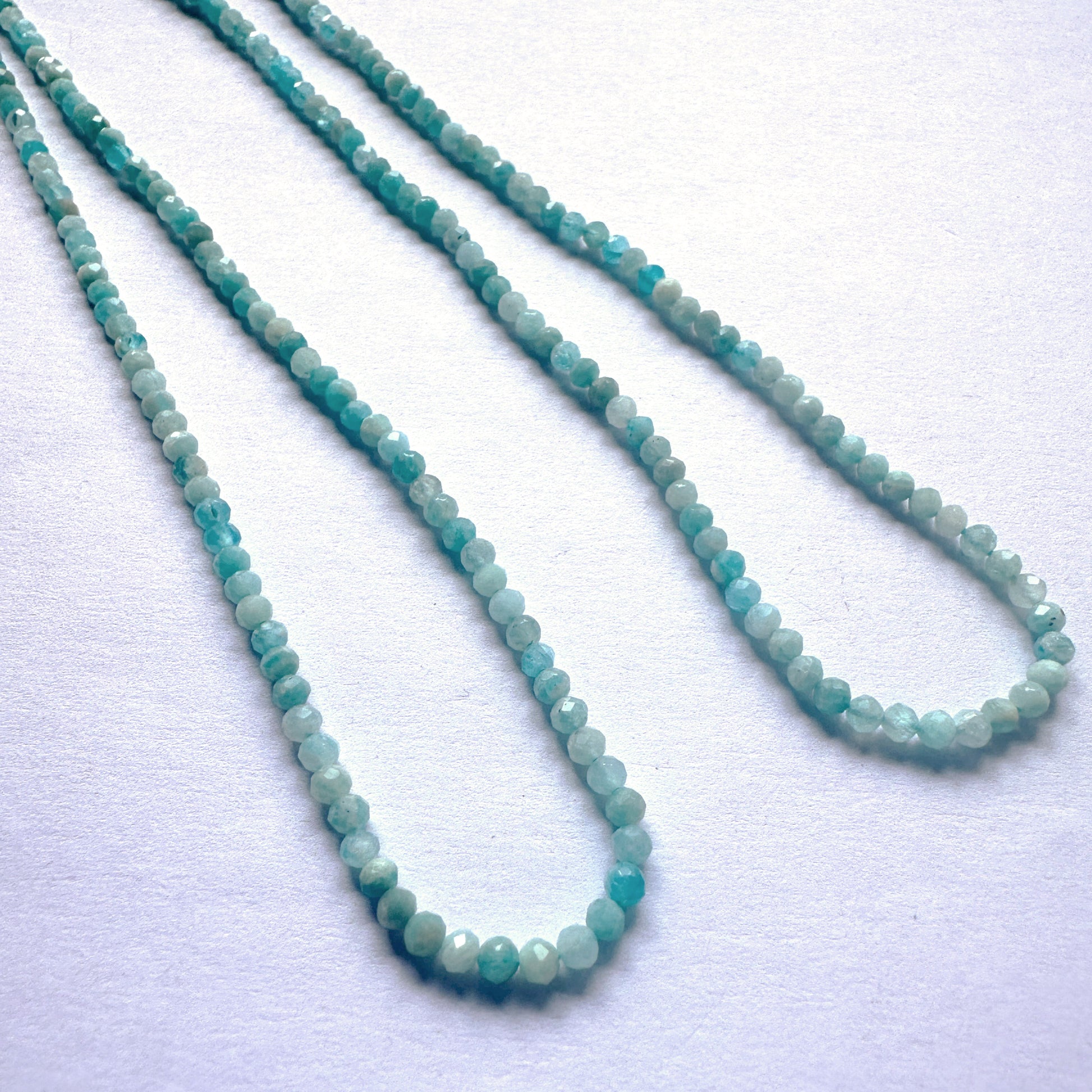 Sparkling Amazonite beads in rondelle cut, reflecting light with subtle brilliance and smooth polish.