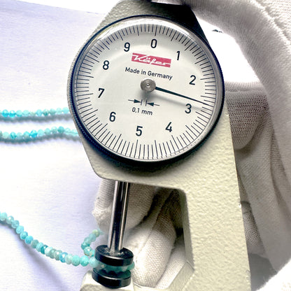 A dial gauge measures the Amazonite faceted rondelle 2.7mm gemstone.