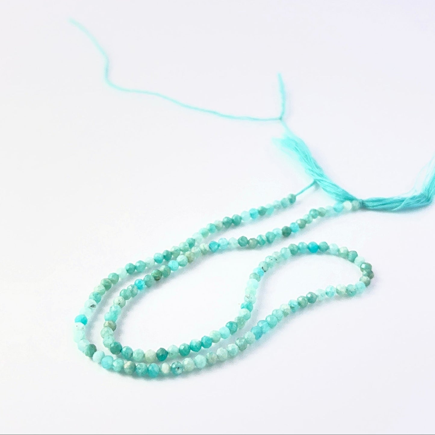 Faceted rondelle Amazonite beads arranged neatly, highlighting their polished finish and handmade jewellery component quality.