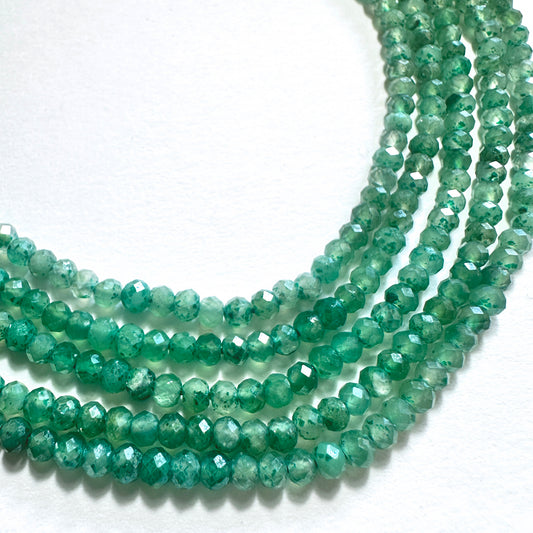 Close-up of green quartz rondelle beads with faceted cuts and consistent 3–3.5mm sizing.