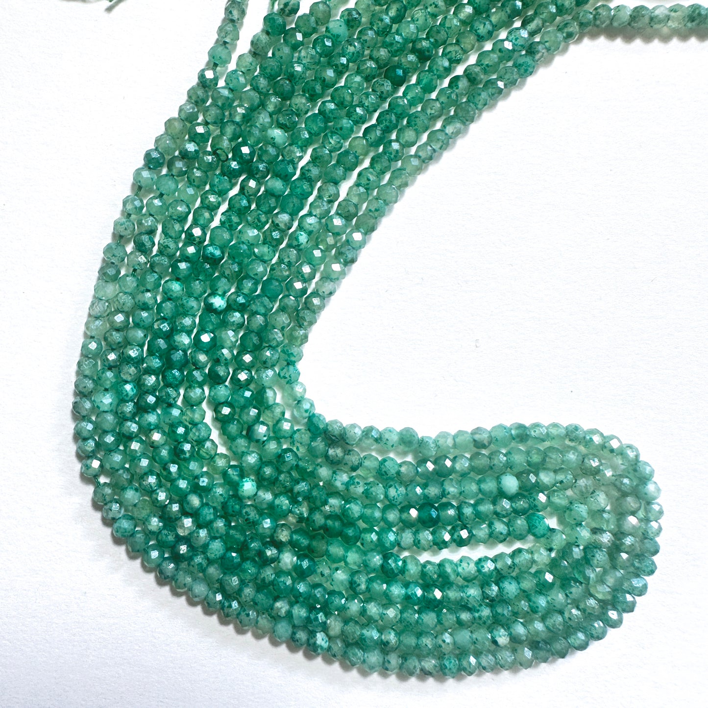 Green faceted rondelle stone beads with a glossy finish, ideal for handmade jewellery components.