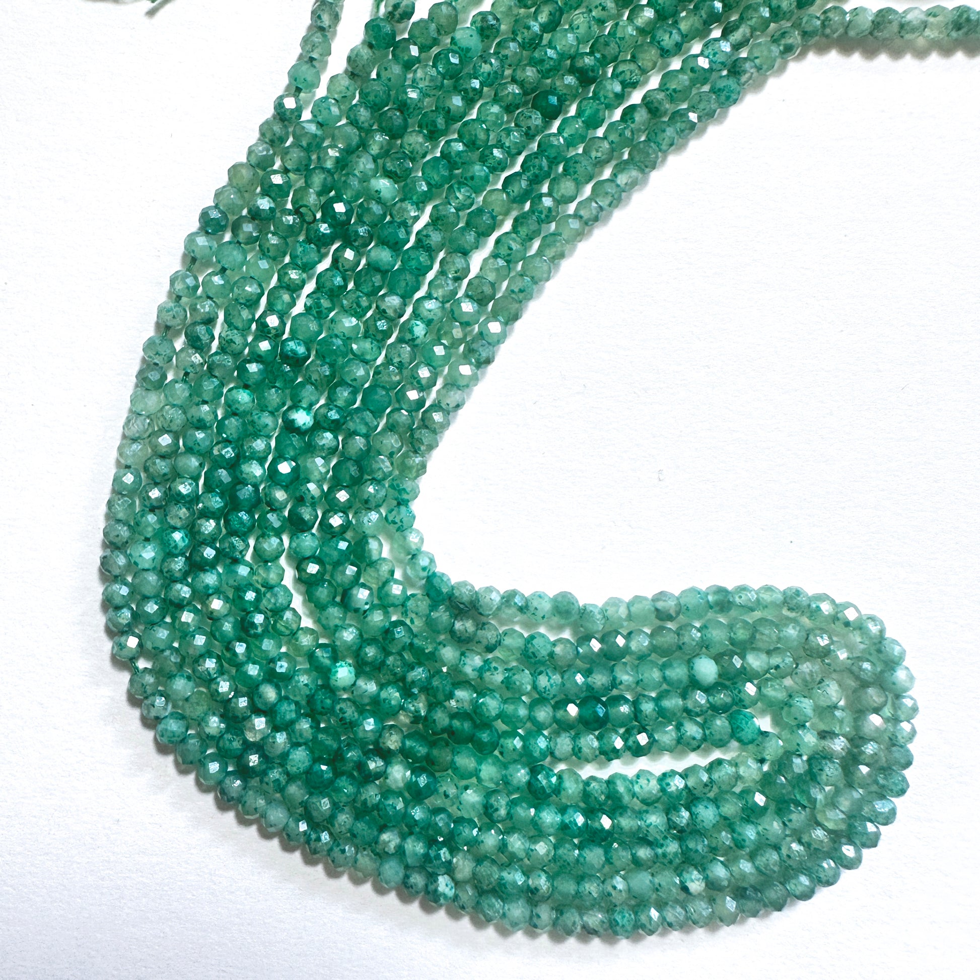 Green faceted rondelle stone beads with a glossy finish, ideal for handmade jewellery components.