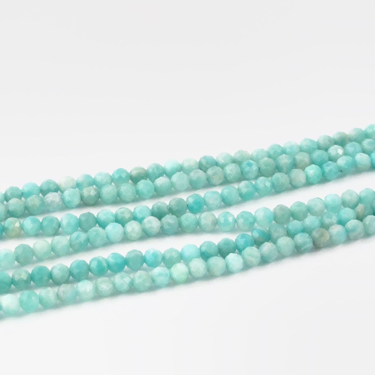 Close up of Amazonite stone beads, 3.4–3.5mm faceted rondelles on a 31cm strand, ideal for jewellery designers