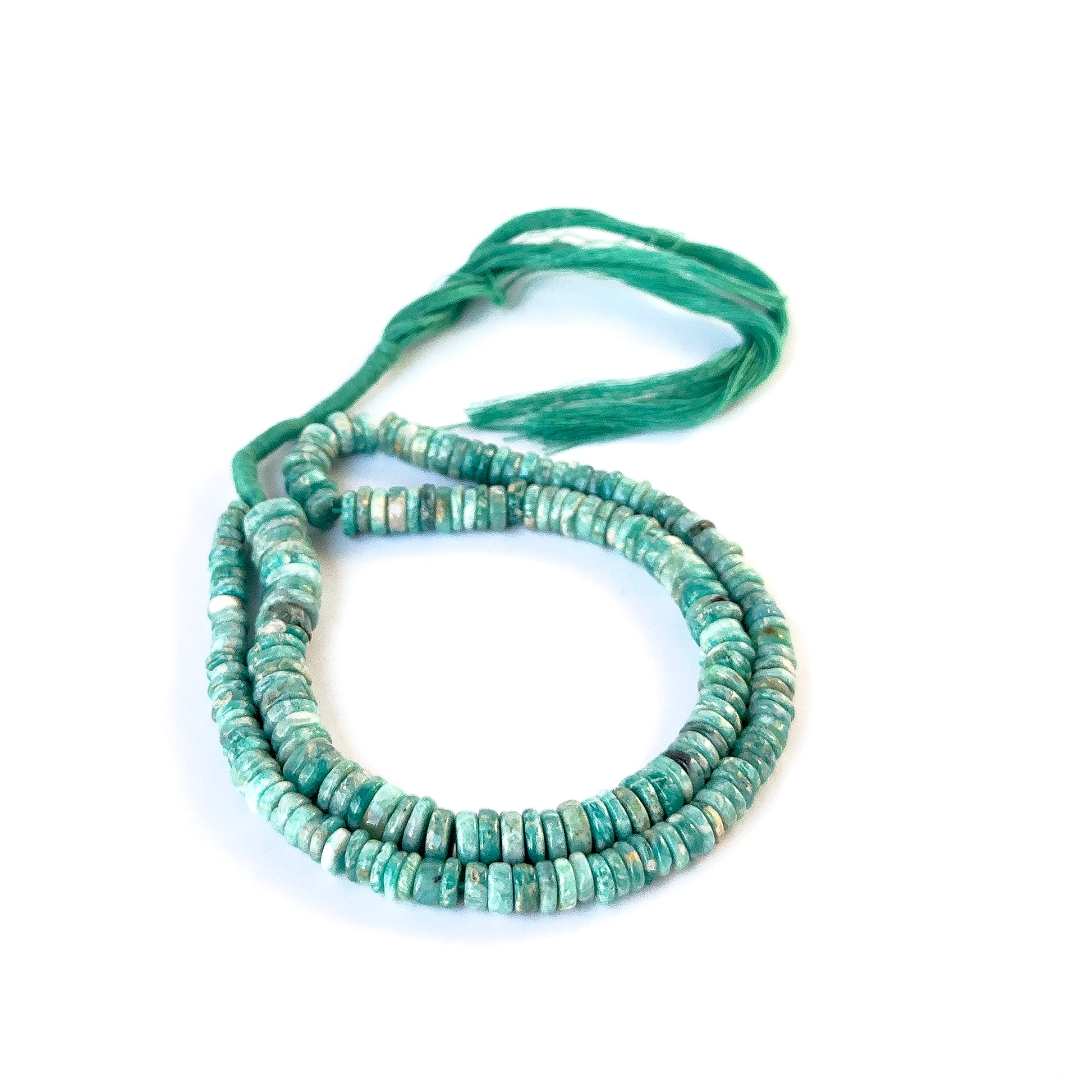 Authentic Amazonite gemstone beads arranged in a strand, highlighting their natural colour and refined finish.