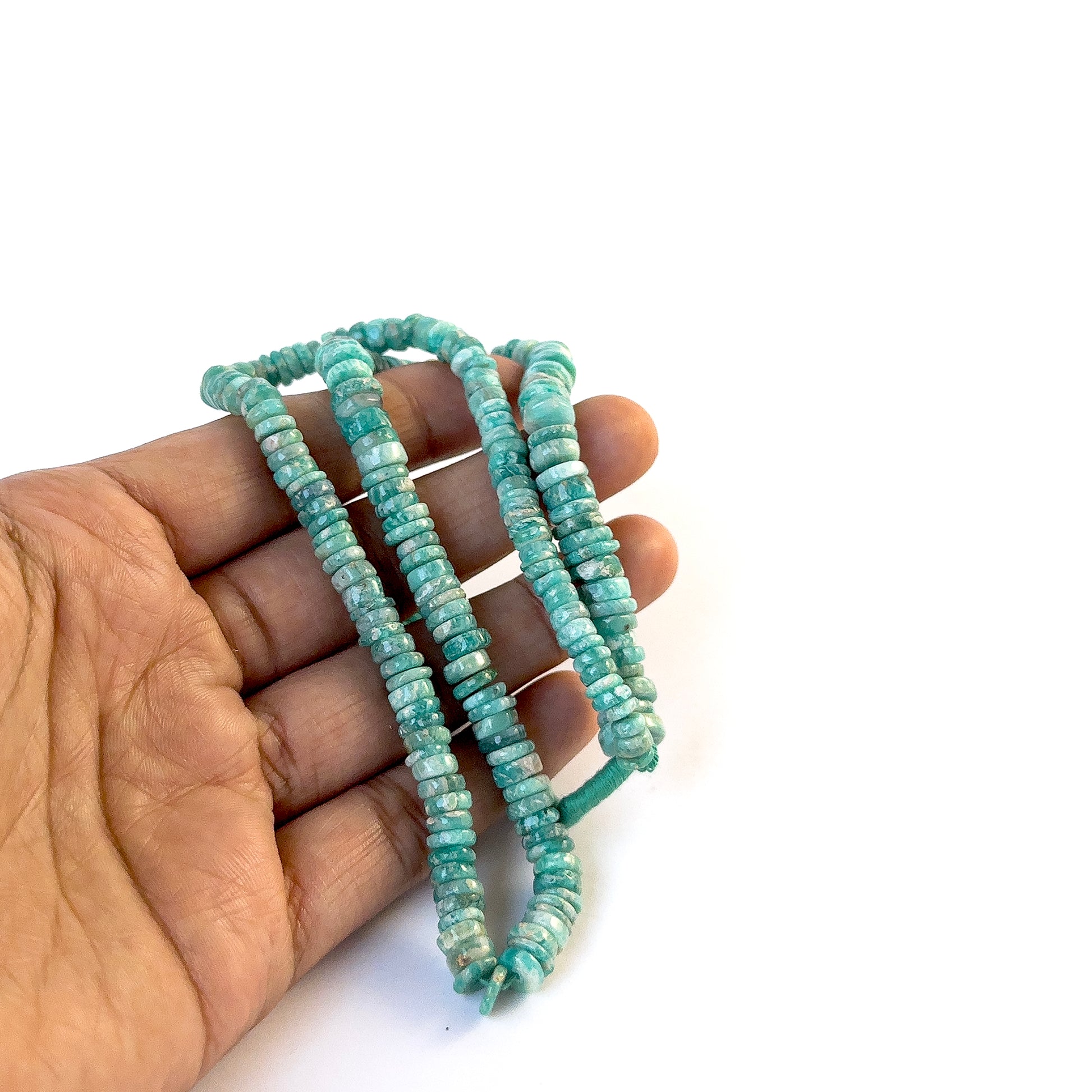 A video person holds delicate strands of Amazonite beads, showcasing their smooth wheel design and sparkle.