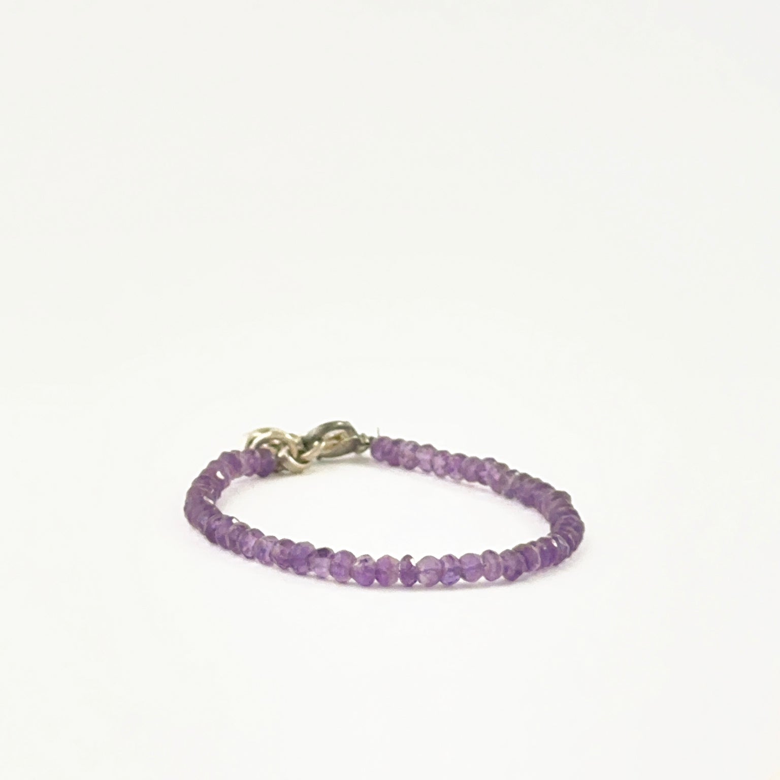 Amethyst bead bracelet arranged with faceted rondelle beads and adjustable fit.