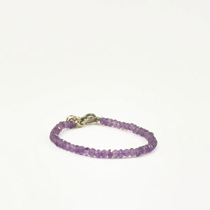 Amethyst bead bracelet arranged with faceted rondelle beads and adjustable fit.