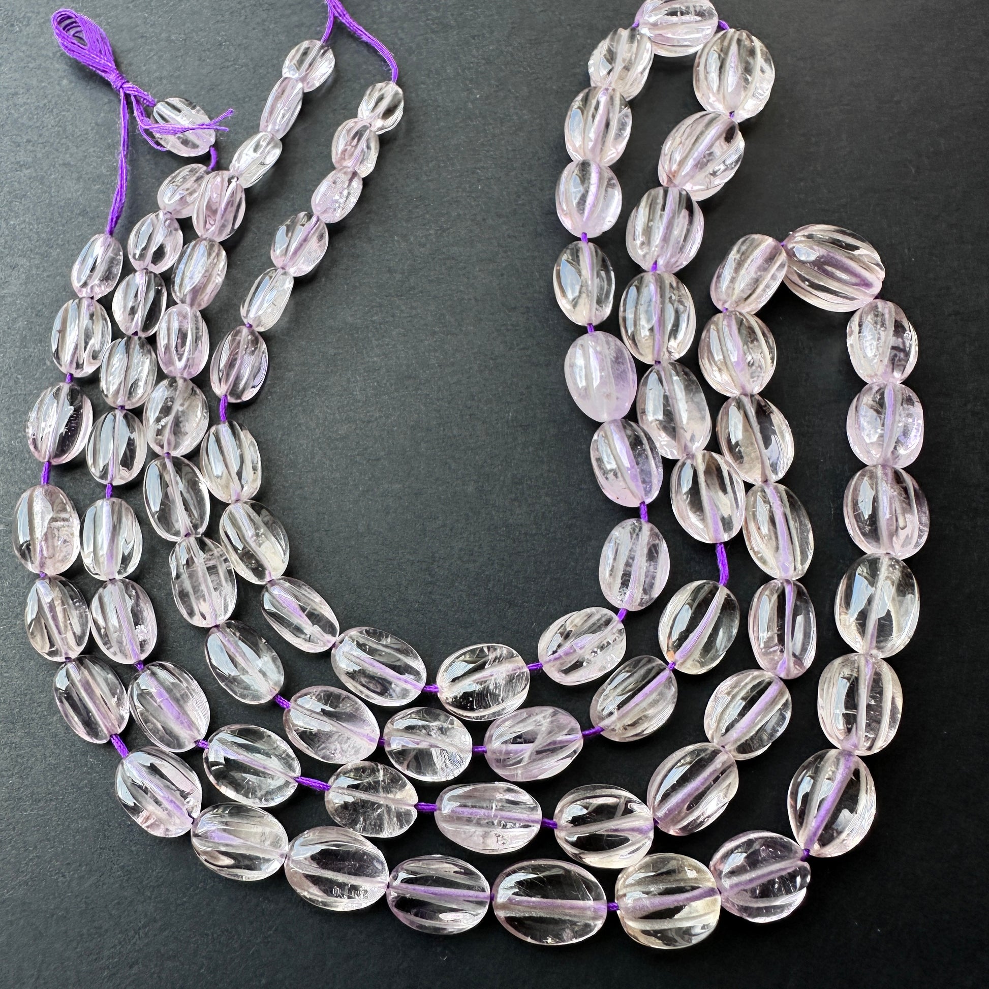 Close-up of natural gemstone beads in graduated sizes from 8x5mm to 13x9mm on a 40cm strand.