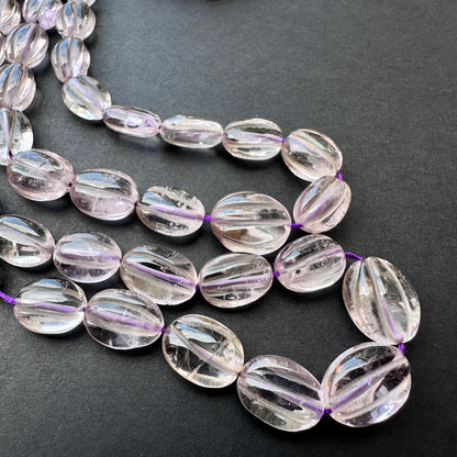 Natural gemstone beads for jewellery featuring smooth oval amethyst stones in vibrant violet hues.