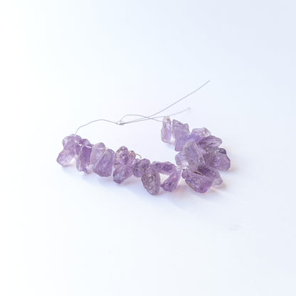 Authentic Amethyst rough gemstone beads displaying deep purple tones and organic uncut texture.