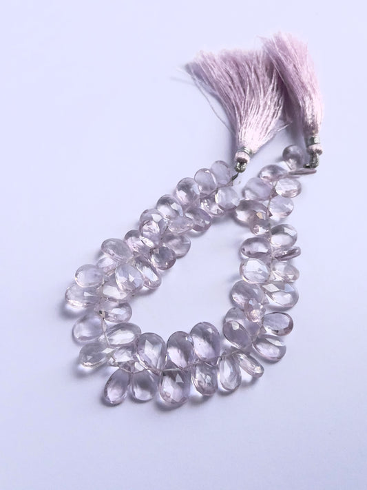 Close-up of natural gemstone beads showing the faceted briolette cut and vibrant Amethyst colour.