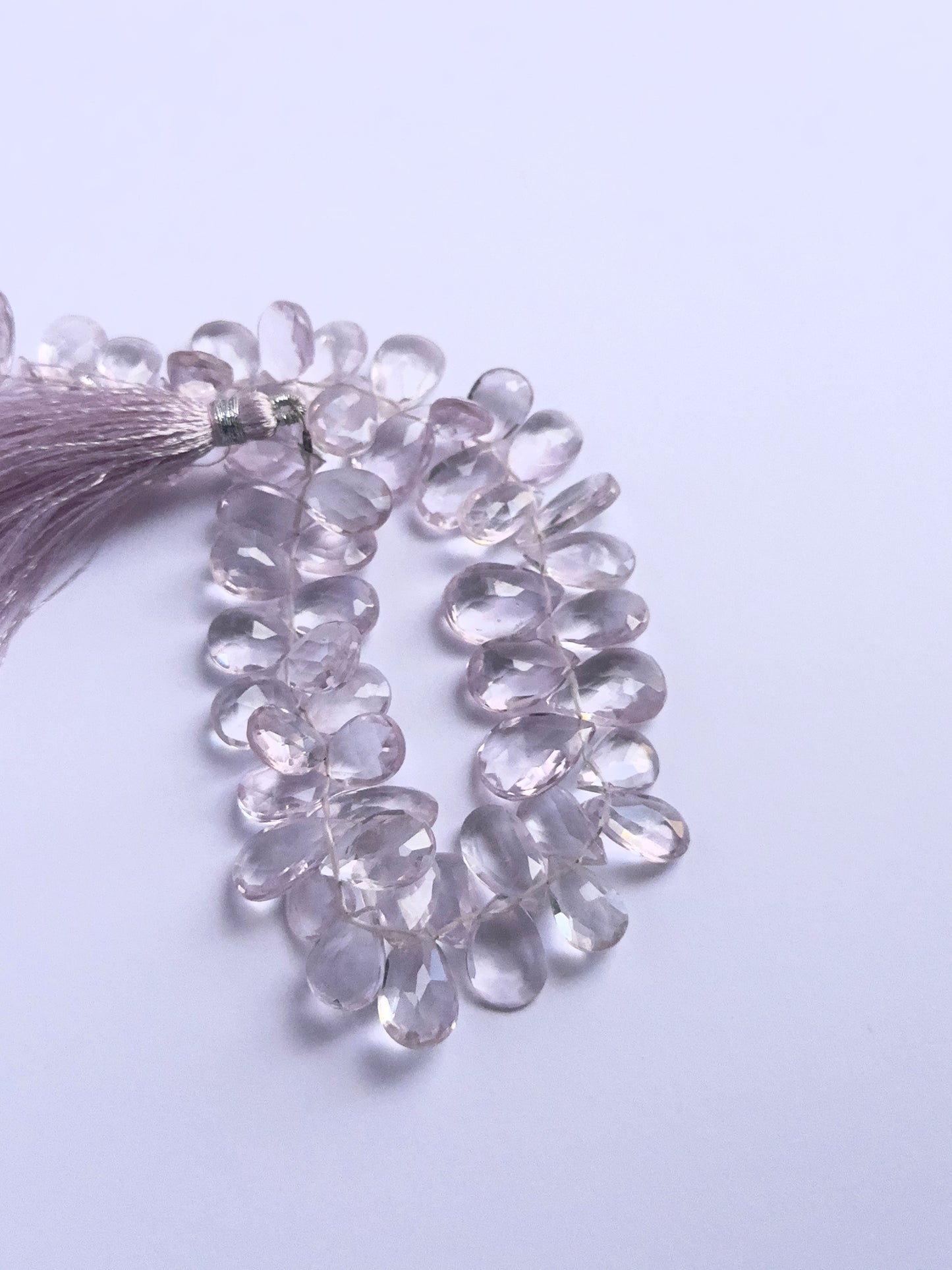 Handmade jewellery components featuring Amethyst faceted briolette beads strung neatly together.