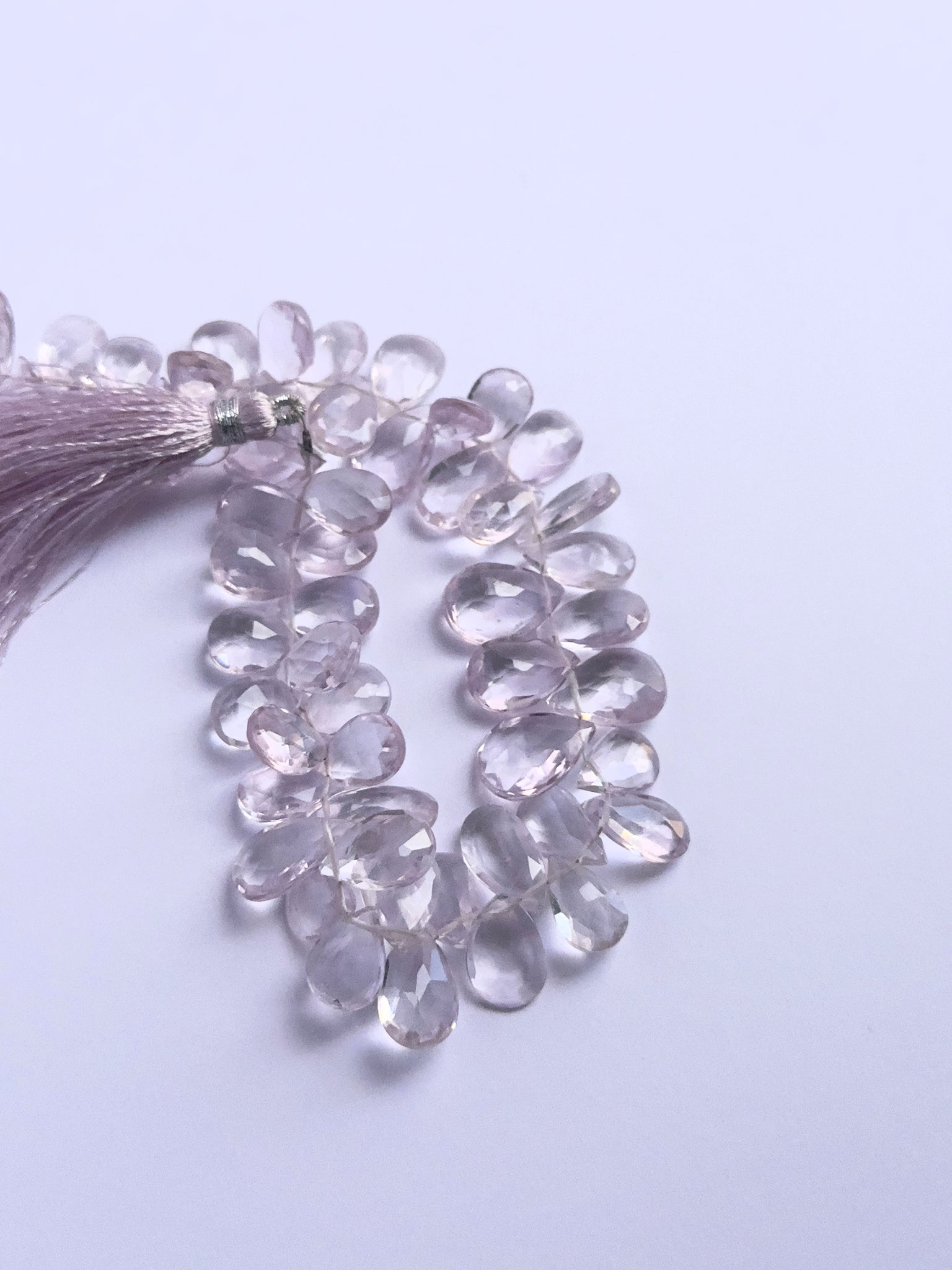 Handmade jewellery components featuring Amethyst faceted briolette beads strung neatly together.