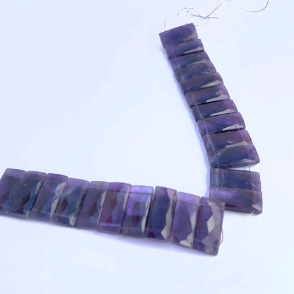 Natural Amethyst stone beads arranged in strands with vibrant purple shimmer.
