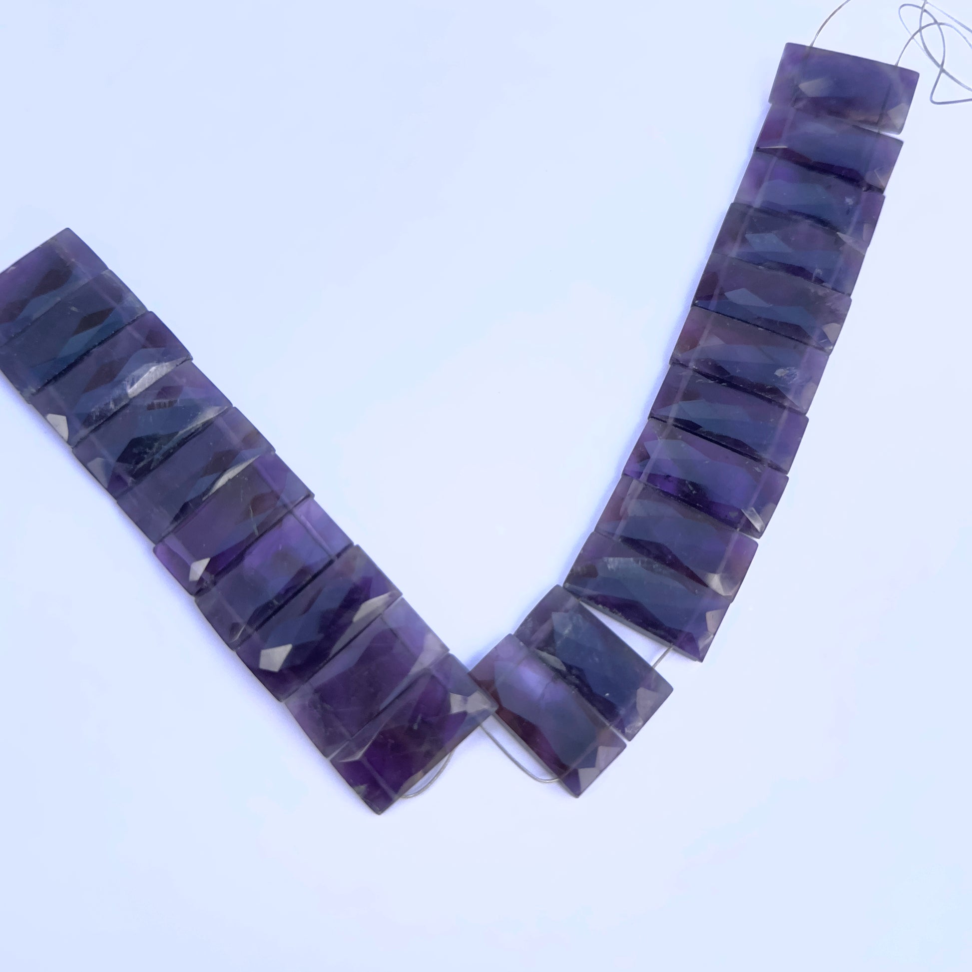Amethyst faceted rectangle gemstone beads on white background.