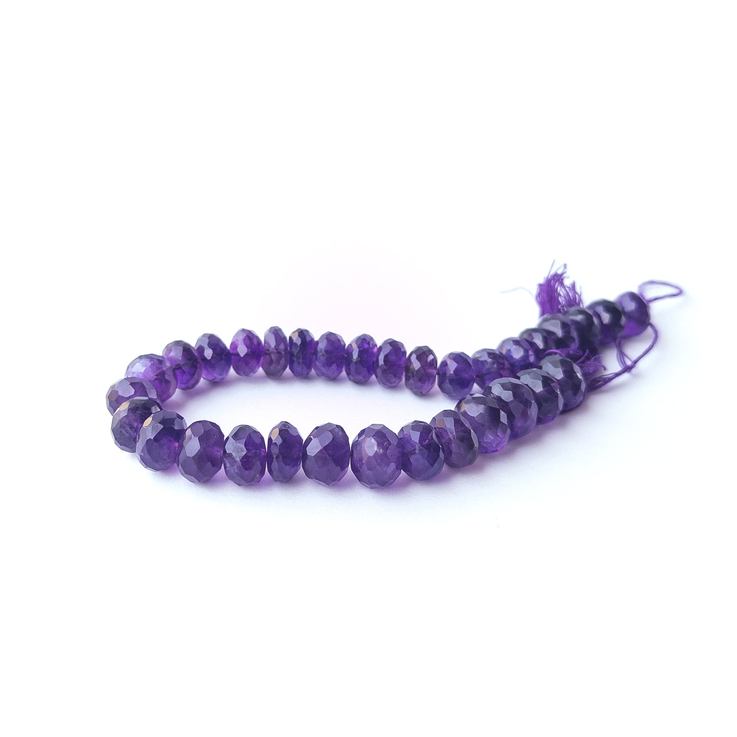 Amethyst faceted rondelle stone beads arranged neatly in a 22cm strand with natural purple brilliance.