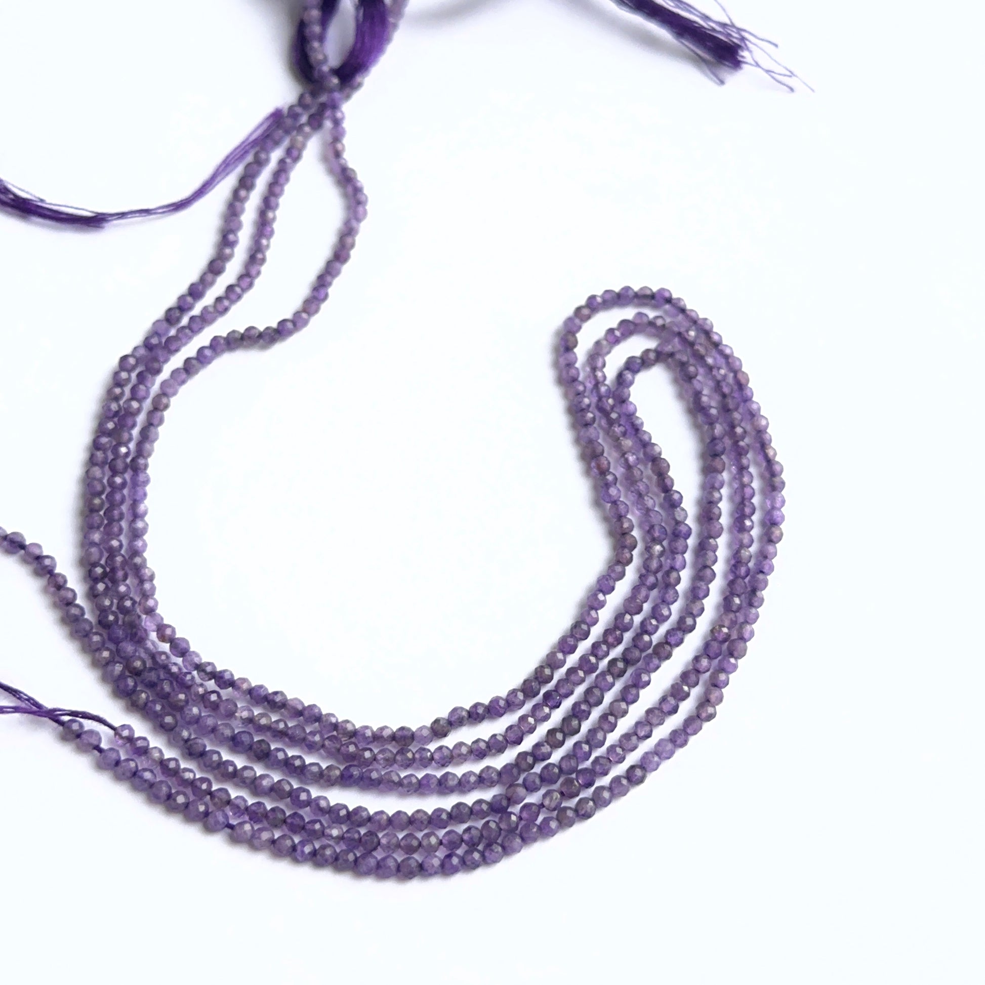 Amethyst gemstone rondelles arranged neatly to showcase clarity, colour and precision faceting.