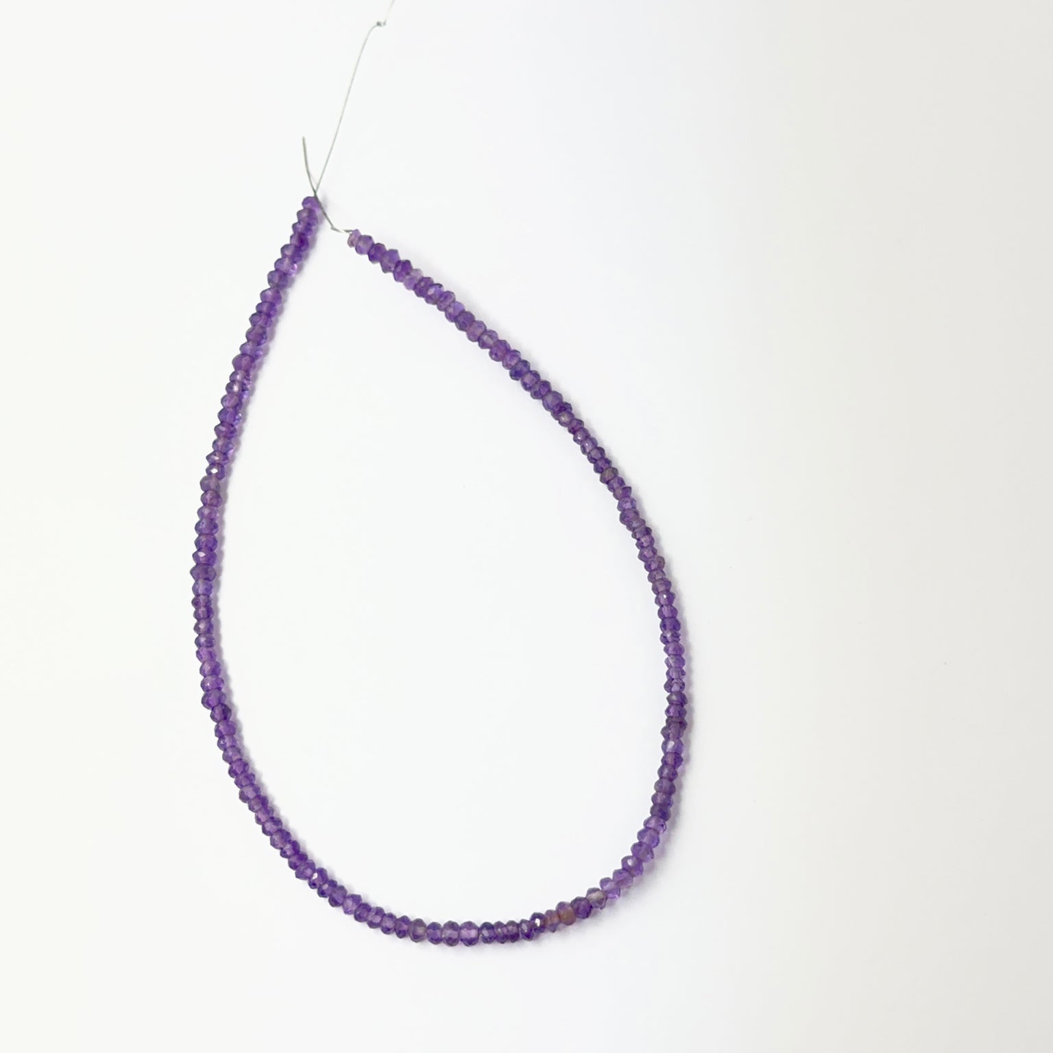 Amethyst faceted rondelle beads aligned on a strand, highlighting clarity, colour and quality stone beads.