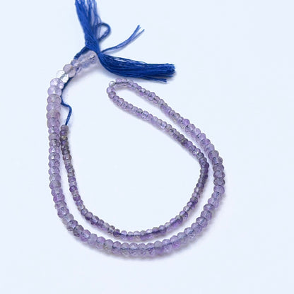 Amethyst gemstone rondelles arranged neatly to showcase clarity, colour and precision faceting.