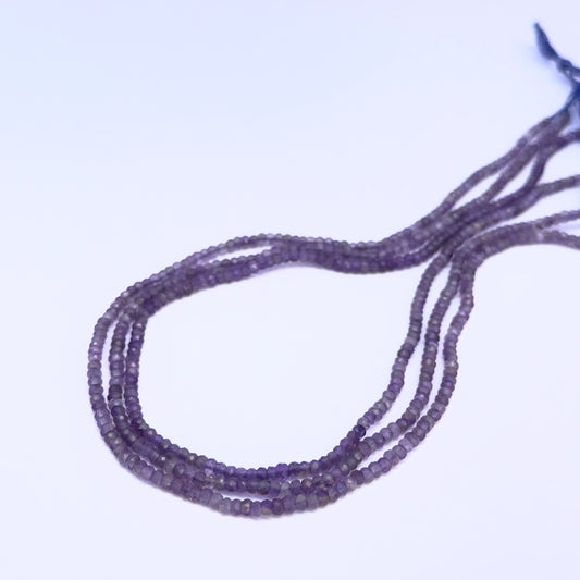 Close-up of Amethyst gemstone beads showing faceted rondelle cut and sparkle.