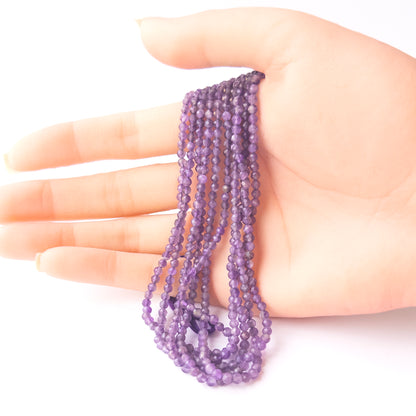 A person holds delicate strands of Amethyst beads, showcasing their faceted rondelle design.