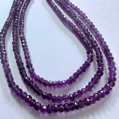 Amethyst gemstone beads in faceted rondelle cut reflect light beautifully across the strand.