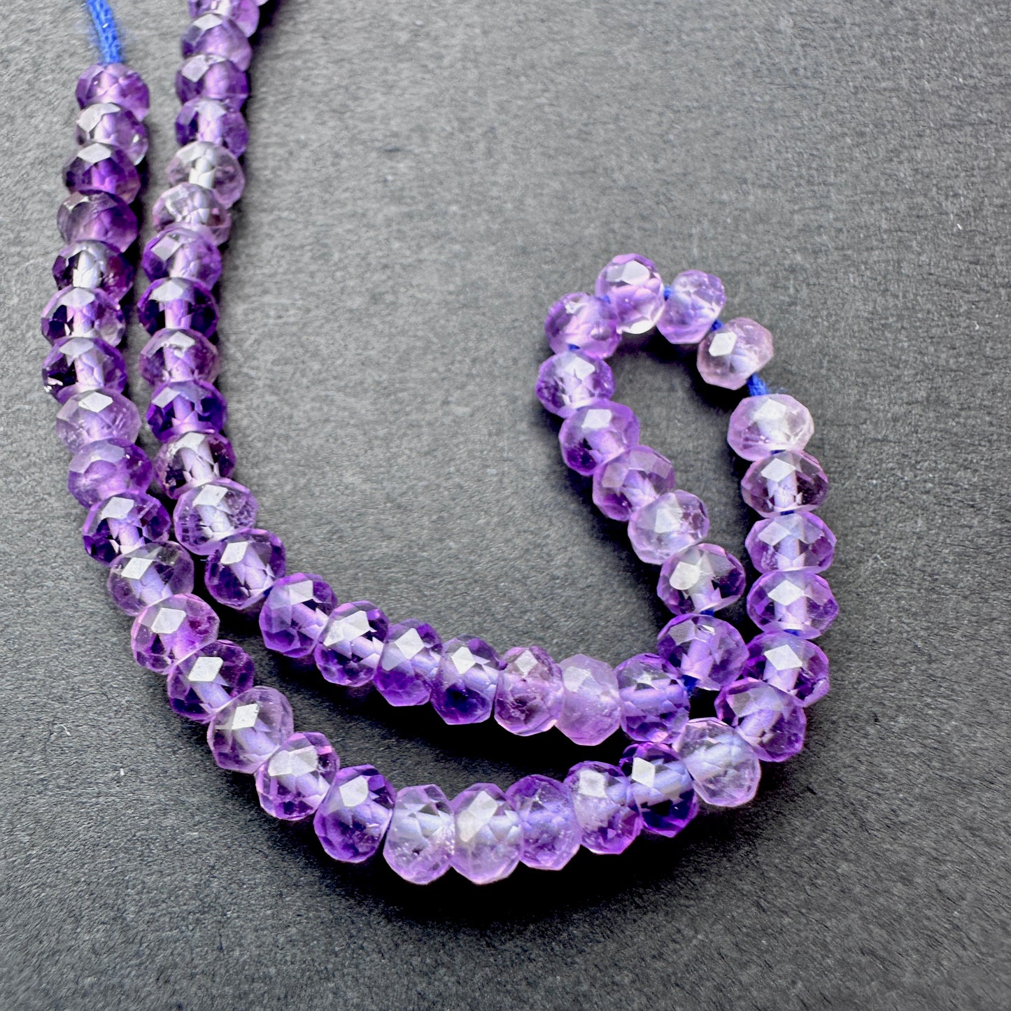 Amethyst faceted rondelle beads with deep purple tones arranged on a 16cm strand for jewellery making.