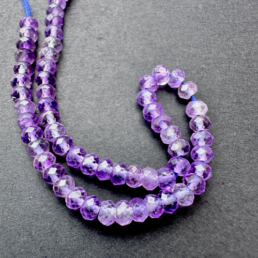 Amethyst faceted rondelle beads with deep purple tones arranged on a 16cm strand for jewellery making.