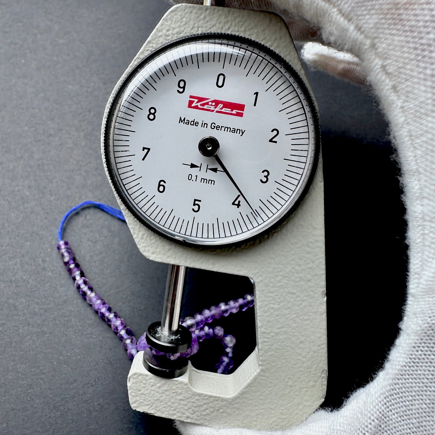 A dial gauge measures the Amethyst faceted rondelle 3.7mm gemstone.