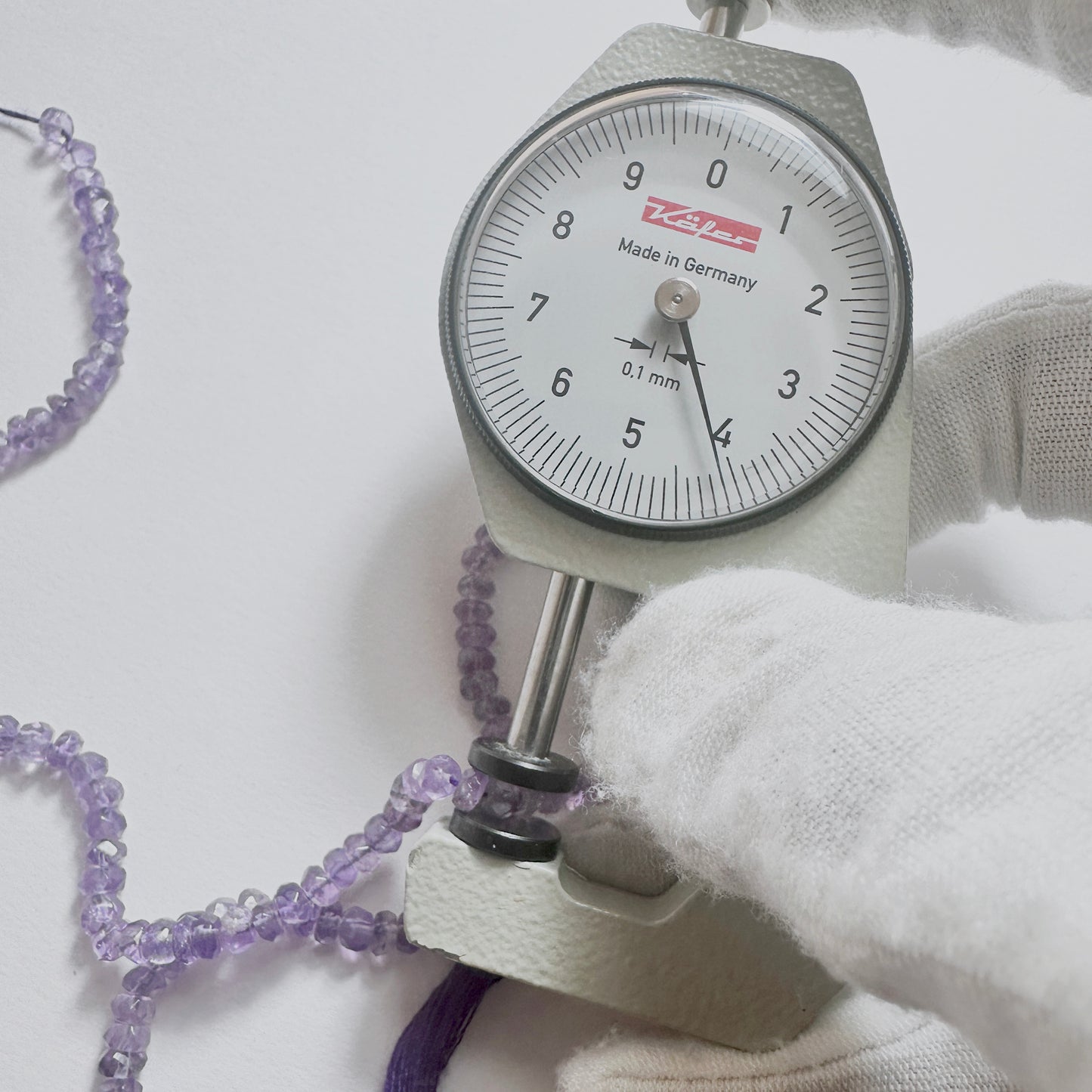 A dial gauge measures the Amethyst faceted rondelle 4.1mm gemstone.