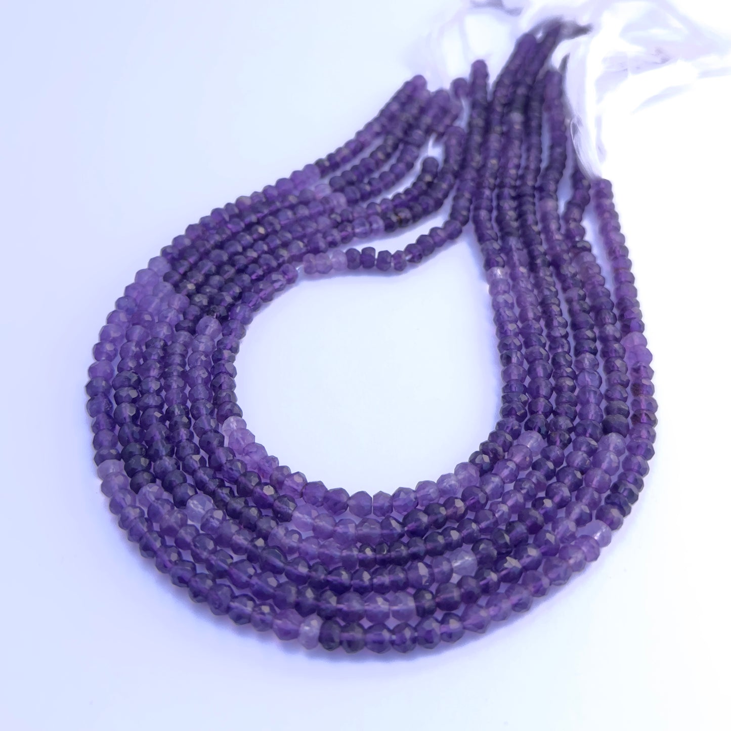 Close-up of Amethyst gemstone beads showing faceted rondelle cut and sparkle.