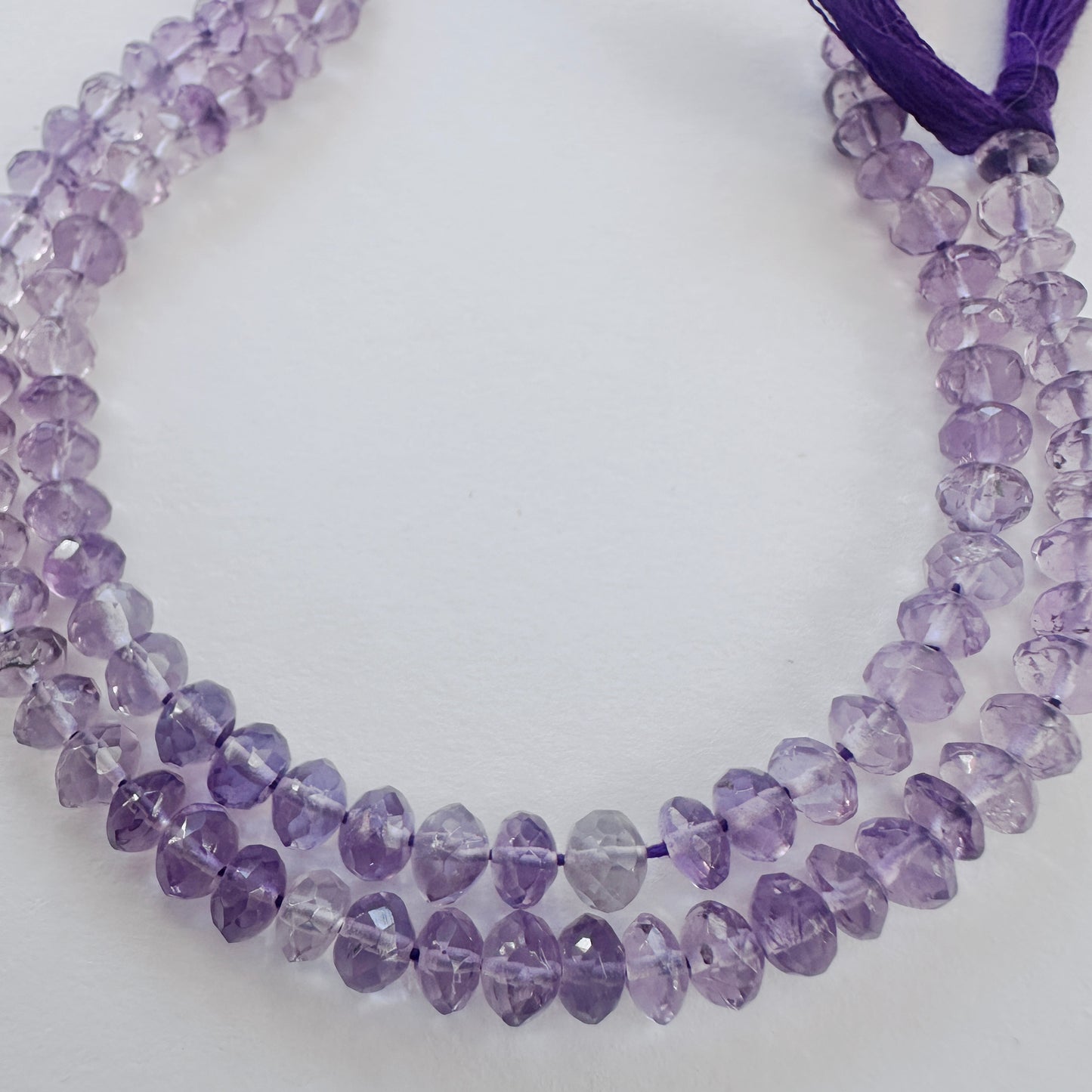 Close-up of Amethyst faceted rondelle beads with deep purple tones and sparkling facets.