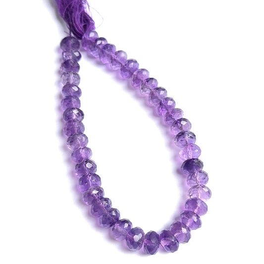 Close‑up of amethyst faceted rondelles highlighting their polished cut and natural gemstone shine.