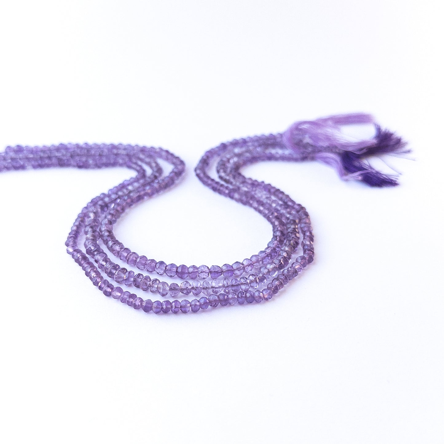 Amethyst faceted rondelle beads in various 3–4.3mm sizes arranged on a 32–34cm strand, showcasing genuine gemstone sparkle.