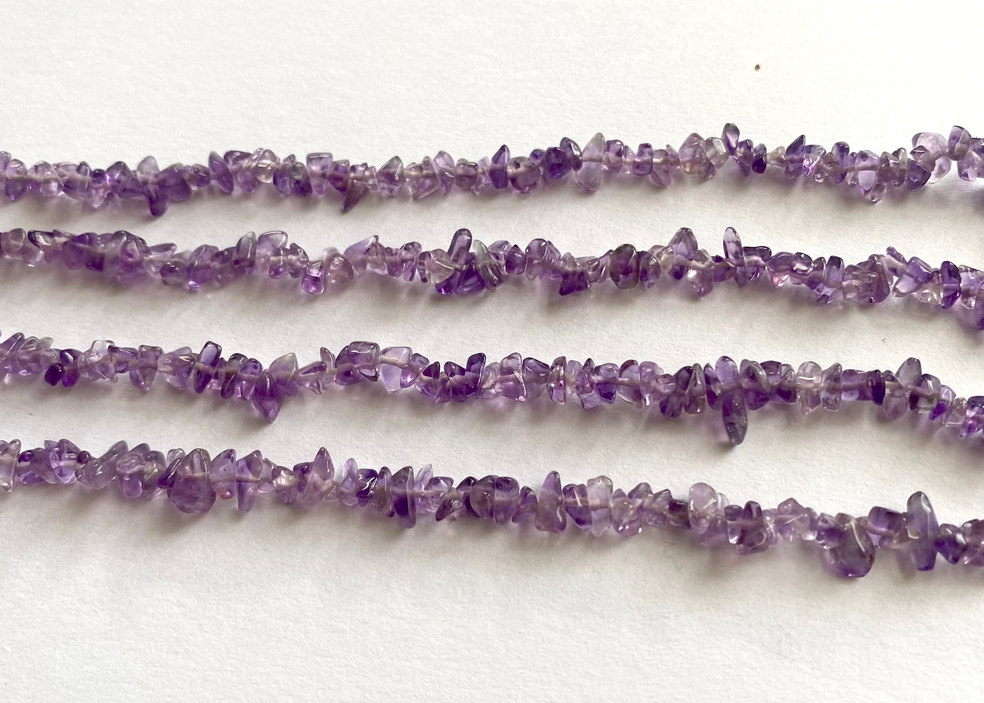 Glossy Amethyst chips threaded on a 44cm strand for jewellery making.