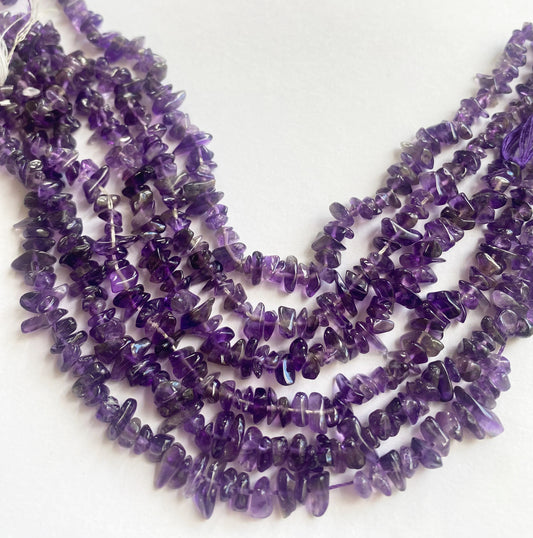 Close-up of polished 5–8.5mm Amethyst chip gemstones showing glossy finish and organic shape.