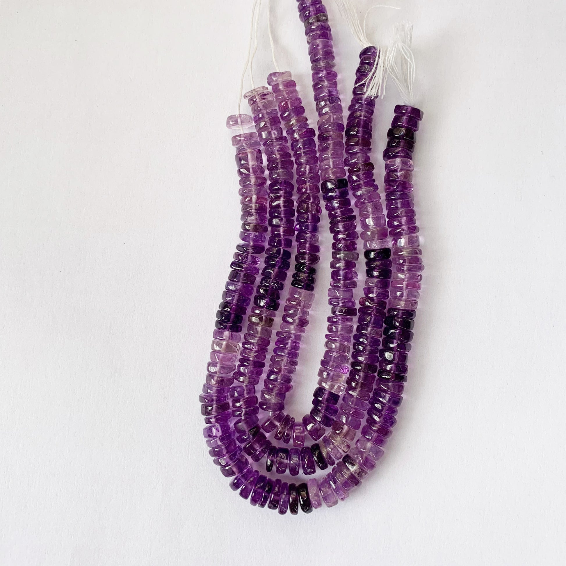 Natural daylight highlights the shine and lustrous texture of Amethyst Heishi cut gemstones.