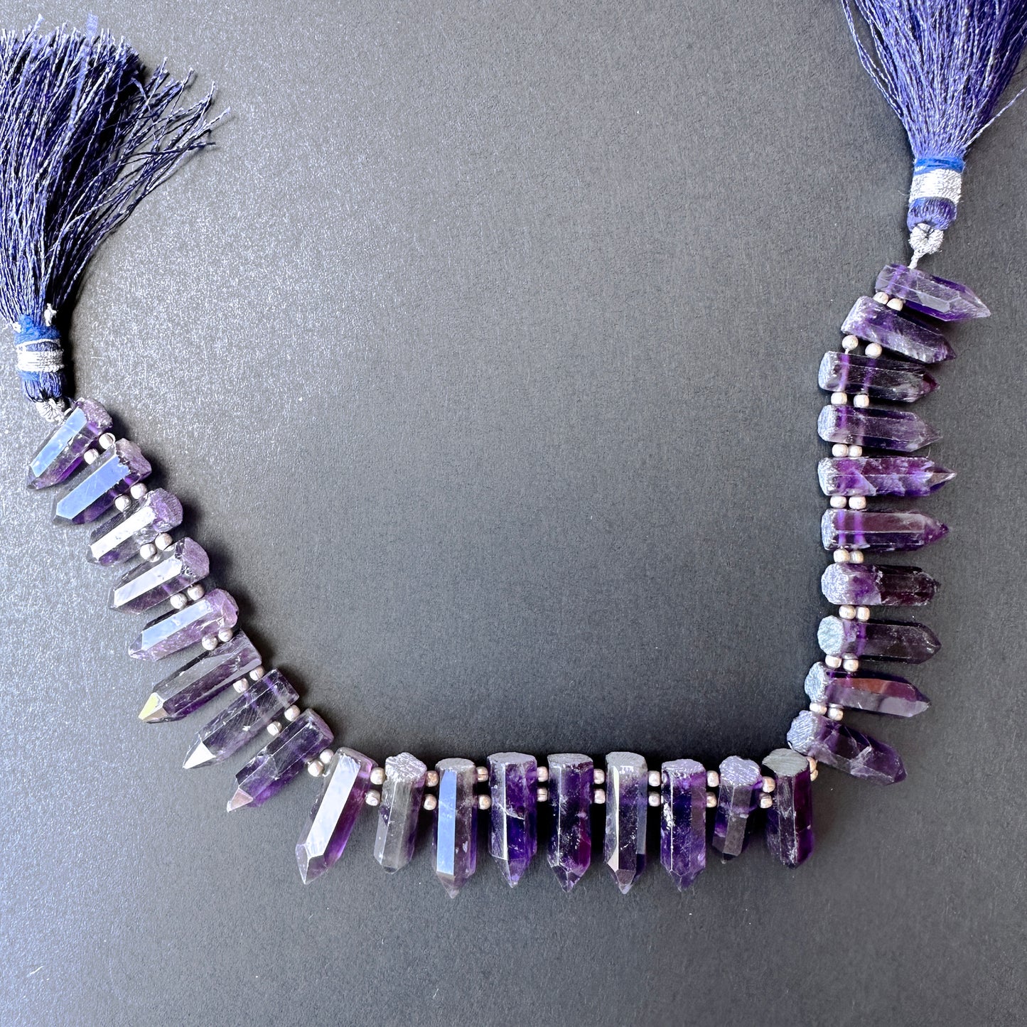 Handmade jewellery components featuring smooth pencil-shaped amethyst beads with 0.5mm holes and 130 carats total weight.