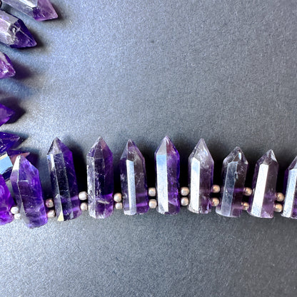 Smooth pencil-shaped amethyst beads.