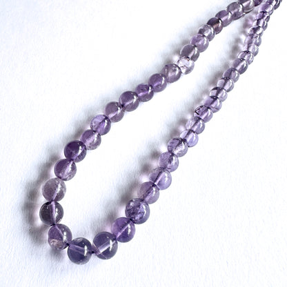 Close-up of Amethyst beads showcasing their glossy surface and rich colour.