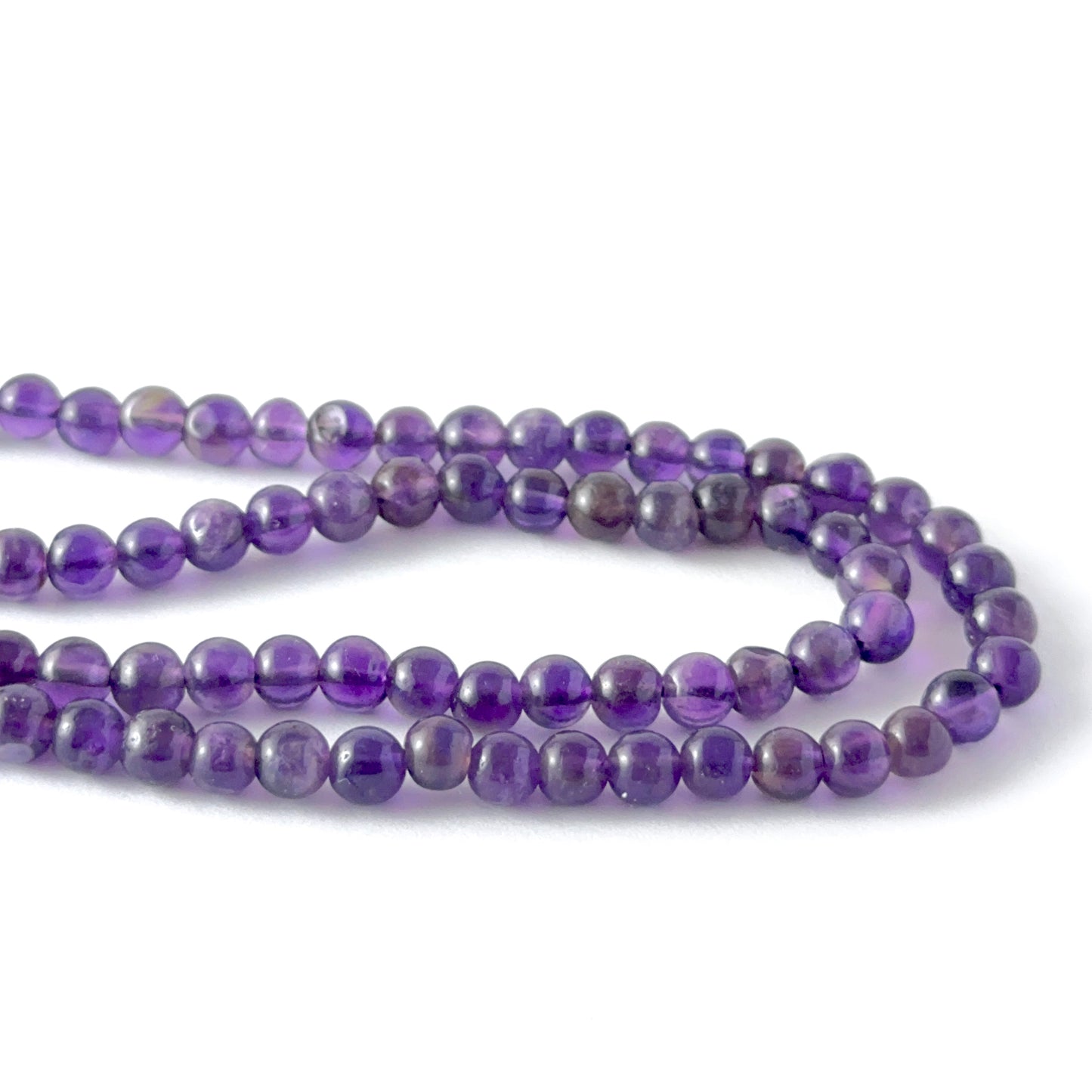 Close view of Amethyst smooth round beads showing clarity, colour and premium gemstone quality for jewellery makers.