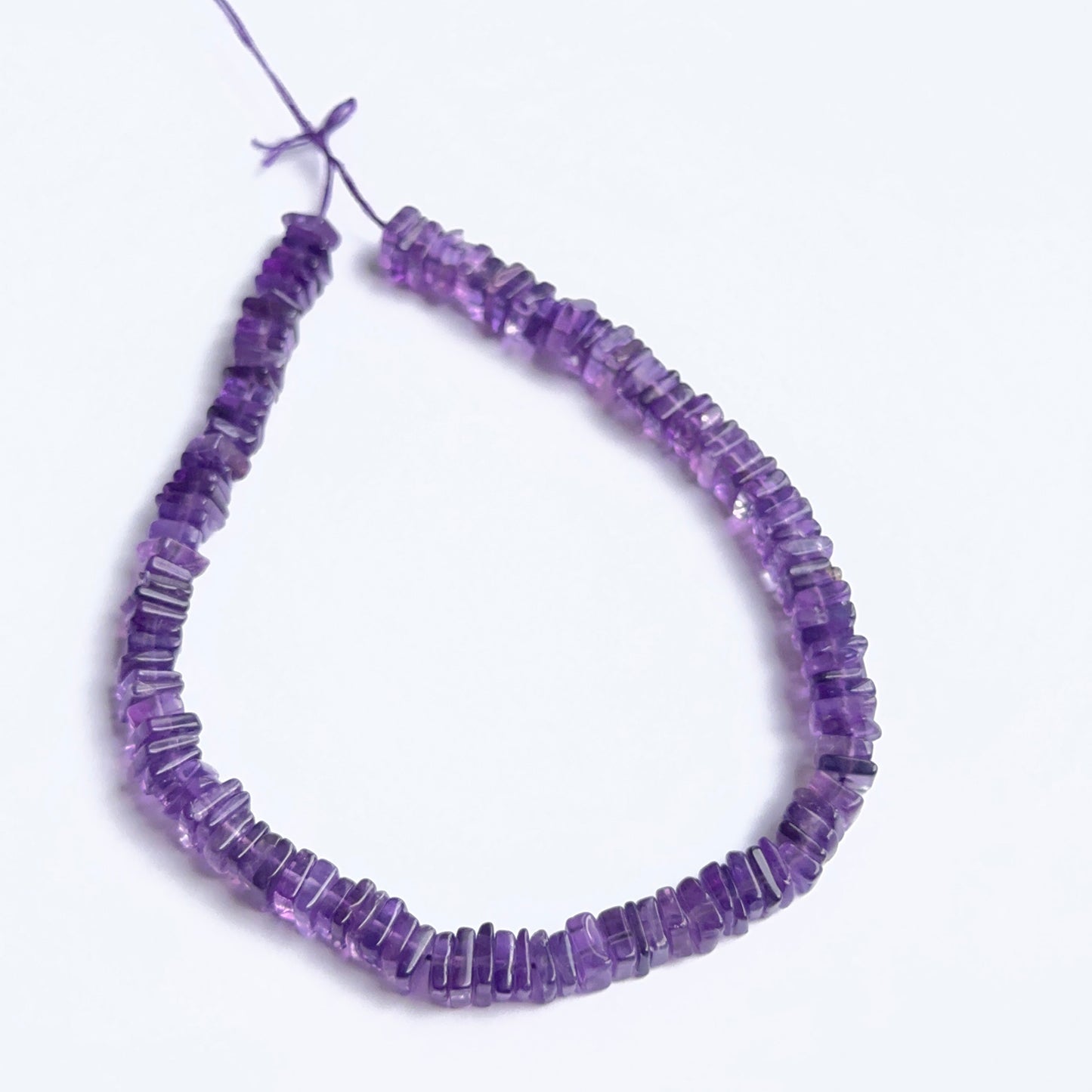 Amethyst square heishi beads arranged neatly to showcase uniform shape, colour and gemstone quality.