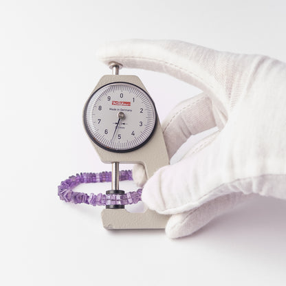 A dial gauge measures the Amethyst Smooth Square Heishi 5.5-6mm gemstone.