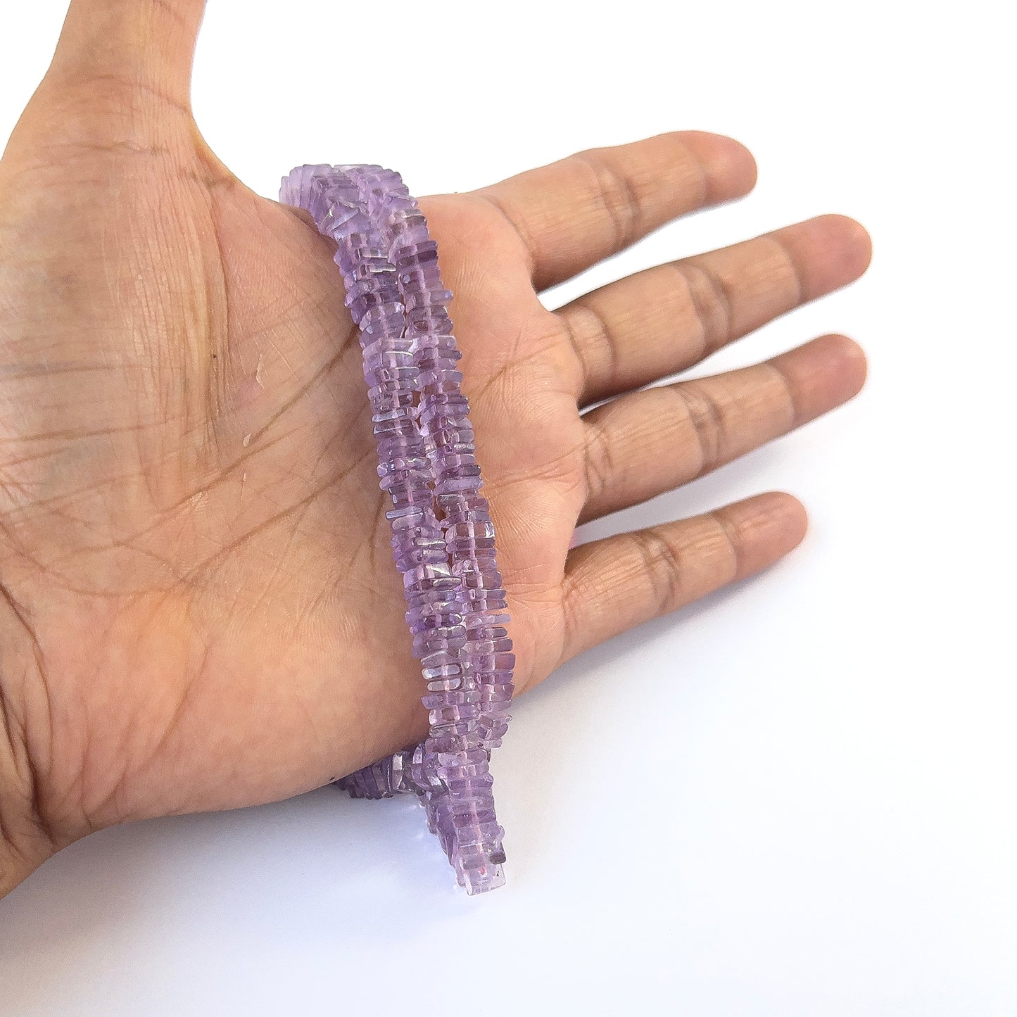 A person holds delicate strands of Amethyst smooth square heishi beads, showcasing their polished design.