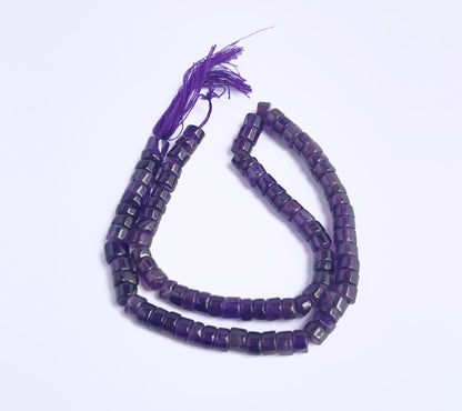 Close-up of Amethyst gemstone beads showing smooth wheel cut and polished finish.