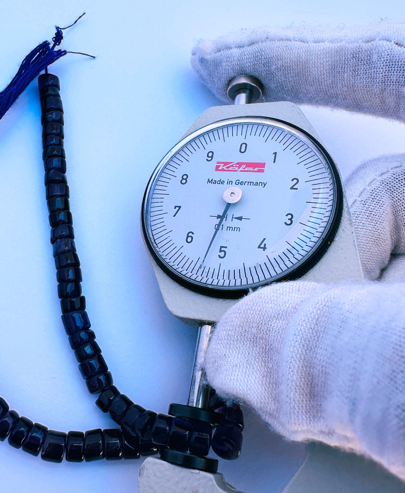 A dial gauge measures the Amethyst smooth wheel 5.5mm gemstone.